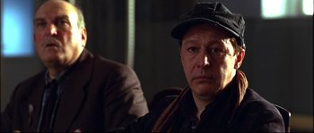 Movie still from “12” (2007), directed by Nikita Mikhalkov – A person wearing a hat; Close Up shot, Over the shoulder angle