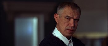 Movie still from “12” (2007), directed by Nikita Mikhalkov – An older man in a white shirt and a black sweater; Close Up shot, Low angle