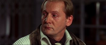 Movie still from “12” (2007), directed by Nikita Mikhalkov – A person wearing a suit and tie; Close Up shot, Low angle