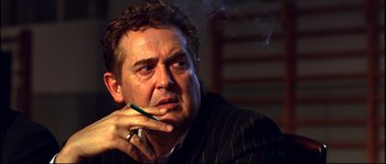 Movie still from “12” (2007), directed by Nikita Mikhalkov – A person smoking a cigarette; Close Up shot, Low angle