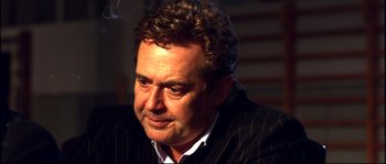 Movie still from “12” (2007), directed by Nikita Mikhalkov – A person wearing a suit and tie; Close Up shot, Low angle