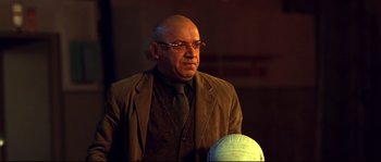 Movie still from “12” (2007), directed by Nikita Mikhalkov – A bald man in a suit and tie with a ball in front of him; Close Up shot, Low angle