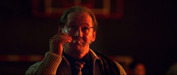 Movie still from “12” (2007), directed by Nikita Mikhalkov – A man in a suit and tie is smoking a cigarette; Close Up shot, Low angle