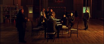 Movie still from “12” (2007), directed by Nikita Mikhalkov – A group of people sitting around a table; Wide shot, High angle