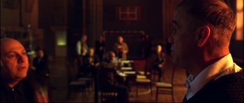 Movie still from “12” (2007), directed by Nikita Mikhalkov – A group of people sitting in a room; Medium shot, Over the shoulder angle