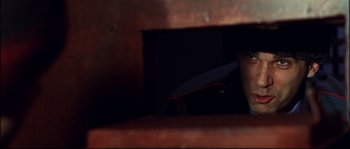 Movie still from “12” (2007), directed by Nikita Mikhalkov – A person holding a skateboard in front of a window; Close Up shot, Low angle