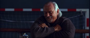 Movie still from “12” (2007), directed by Nikita Mikhalkov – An older man sitting on top of a wooden bench; Close Up shot, Low angle