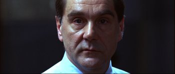 Movie still from “12” (2007), directed by Nikita Mikhalkov – A man's face in a white dress shirt; Close Up shot, Low angle