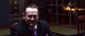 Movie still from “12” (2007), directed by Nikita Mikhalkov – A person wearing a suit and tie; Close Up shot, Over the shoulder angle