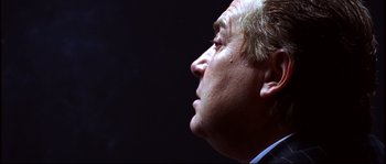 Movie still from “12” (2007), directed by Nikita Mikhalkov – A man's face in a dark room; Close Up shot, Low angle