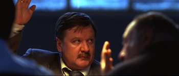 Movie still from “12” (2007), directed by Nikita Mikhalkov – A person wearing a suit and tie; Close Up shot, Over the shoulder angle