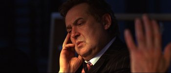 Movie still from “12” (2007), directed by Nikita Mikhalkov – A person wearing a suit holding a cell phone to his ear; Close Up shot, Low angle