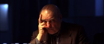 Movie still from “12” (2007), directed by Nikita Mikhalkov – An older man in a brown jacket and a black tie; Close Up shot, High angle