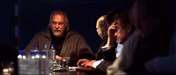 Movie still from “12” (2007), directed by Nikita Mikhalkov – A group of people sitting around a table; Medium shot, Low angle