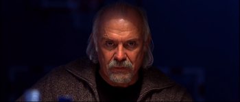 Movie still from “12” (2007), directed by Nikita Mikhalkov – An older man with a gray beard stares at the camera; Close Up shot, Low angle