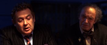 Movie still from “12” (2007), directed by Nikita Mikhalkov – A person wearing a suit and tie; Close Up shot, Over the shoulder angle