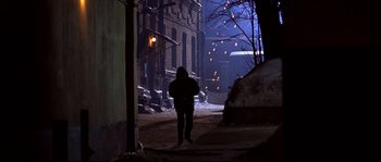 Movie still from “12” (2007), directed by Nikita Mikhalkov – A person standing on a street at night; Wide shot, High angle