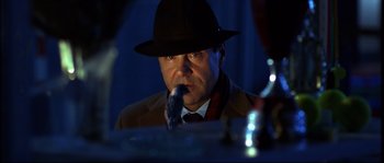 Movie still from “12” (2007), directed by Nikita Mikhalkov – A man wearing a hat is eating something while sitting at a table; Close Up shot, Low angle
