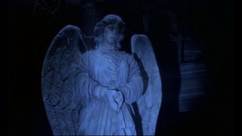 Movie still from “12 Monkeys” (1995), directed by Terry Gilliam – A statue of an archangel in the dark; Wide shot, High angle