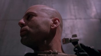 Movie still from “12 Monkeys” (1995), directed by Terry Gilliam – A man with a bald head is looking up; Close Up shot, Low angle