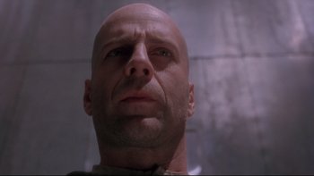 Movie still from “12 Monkeys” (1995), directed by Terry Gilliam – A bald man is looking into the distance; Close Up shot, Low angle