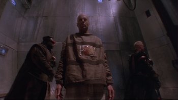 Movie still from “12 Monkeys” (1995), directed by Terry Gilliam – A group of people standing around in a room; Medium shot, Low angle