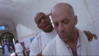 Movie still from “12 Monkeys” (1995), directed by Terry Gilliam – A bald man is holding a towel over his face; Close Up shot, Low angle