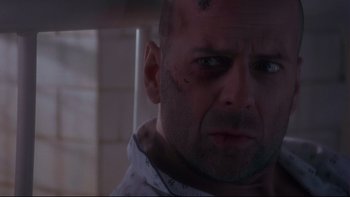 Movie still from “12 Monkeys” (1995), directed by Terry Gilliam – A bald man with a scar on his face stares into the camera; Close Up shot, Low angle