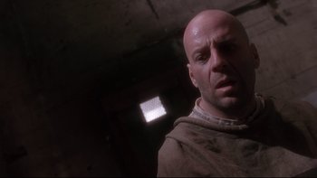 Movie still from “12 Monkeys” (1995), directed by Terry Gilliam – A bald man with a shaved head is looking at the camera; Close Up shot, Low angle