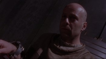 Movie still from “12 Monkeys” (1995), directed by Terry Gilliam – A bald man with a beard is looking up at the ceiling; Close Up shot, Low angle