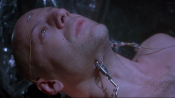 Movie still from “12 Monkeys” (1995), directed by Terry Gilliam – A person with a chain around their neck; Close Up shot, High angle