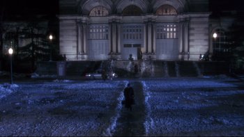 Movie still from “12 Monkeys” (1995), directed by Terry Gilliam – A person standing in the middle of a street at night; Extreme Wide shot, High angle