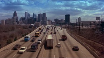 Movie still from “12 Monkeys” (1995), directed by Terry Gilliam – A busy highway with a bunch of cars on it; Extreme Wide shot, High angle