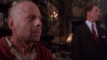 Movie still from “12 Monkeys” (1995), directed by Terry Gilliam – A man in a red shirt is looking at the camera; Close Up shot, Over the shoulder angle