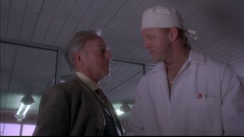 Movie still from “12 Monkeys” (1995), directed by Terry Gilliam – A man and an older man talking to each other; Close Up shot, Low angle