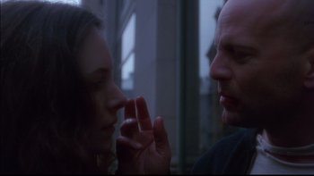 Movie still from “12 Monkeys” (1995), directed by Terry Gilliam – A man and a woman face to face in front of a building; Close Up shot, Over the shoulder angle