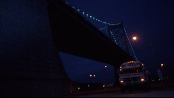 Movie still from “12 Monkeys” (1995), directed by Terry Gilliam – A bus driving under a bridge at night time; Extreme Wide shot, Low angle