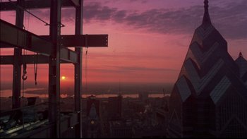 Movie still from “12 Monkeys” (1995), directed by Terry Gilliam – The sun is setting over a city skyline; Extreme Wide shot, Low angle