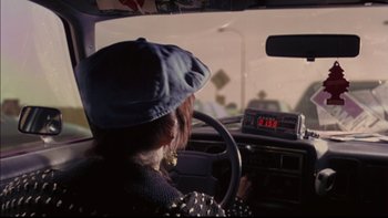 Movie still from “12 Monkeys” (1995), directed by Terry Gilliam – A woman driving a car with a hat on; Close Up shot, Over the shoulder angle