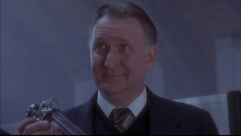 Movie still from “12 Monkeys” (1995), directed by Terry Gilliam – A person wearing a suit and tie; Close Up shot, Low angle