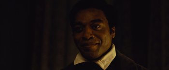 Movie still from “12 Years a Slave” (2013), directed by Steve McQueen – A person wearing a shirt and tie; Close Up shot, Over the shoulder angle