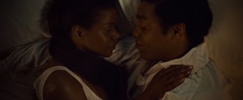Movie still from “12 Years a Slave” (2013), directed by Steve McQueen – A man and a woman laying on a bed together; Close Up shot, Overhead angle