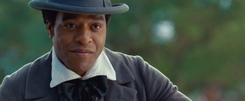 Movie still from “12 Years a Slave” (2013), directed by Steve McQueen – A person wearing a hat and a tie; Close Up shot, Over the shoulder angle