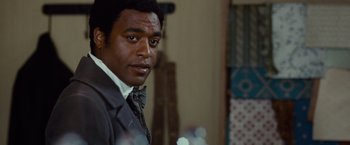 Movie still from “12 Years a Slave” (2013), directed by Steve McQueen – A person wearing a suit and tie; Close Up shot, Over the shoulder angle