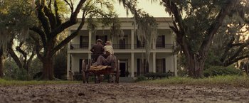 Movie still from “12 Years a Slave” (2013), directed by Steve McQueen – Two men sitting on top of a wagon in front of a house; Extreme Wide shot, Low angle