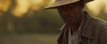 Movie still from “12 Years a Slave” (2013), directed by Steve McQueen – A person wearing a hat; Close Up shot, Over the shoulder angle