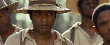 Movie still from “12 Years a Slave” (2013), directed by Steve McQueen – A person wearing a hat; Close Up shot, Over the shoulder angle