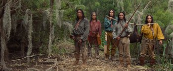 Movie still from “12 Years a Slave” (2013), directed by Steve McQueen – A group of native americans standing next to each other in the woods; Wide shot, Low angle