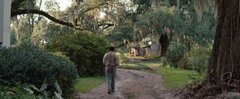 Movie still from “12 Years a Slave” (2013), directed by Steve McQueen – A man walking down a dirt road in a wooded area; Extreme Wide shot, Over the shoulder angle