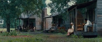 Movie still from “12 Years a Slave” (2013), directed by Steve McQueen – A group of people sitting on a porch of an old house; Extreme Wide shot, High angle